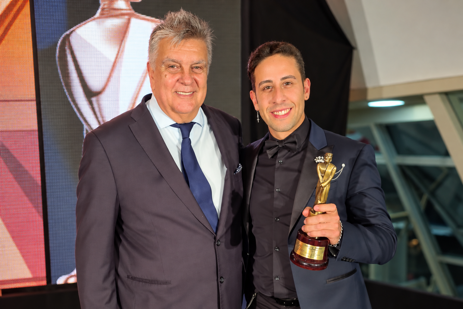 Emanuel Rivero Famá junto a un invitado y el premio Martín Fierro Federal